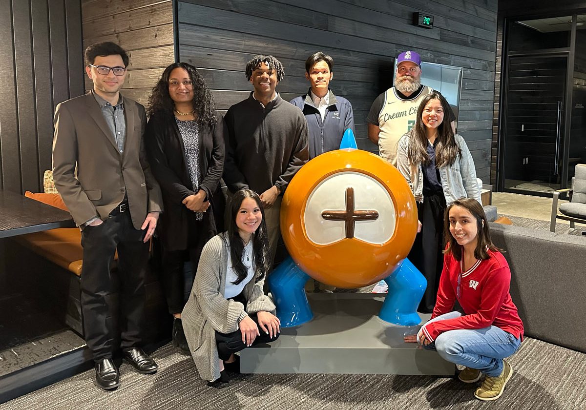 A group of students stand and kneel together to pose for the camera.